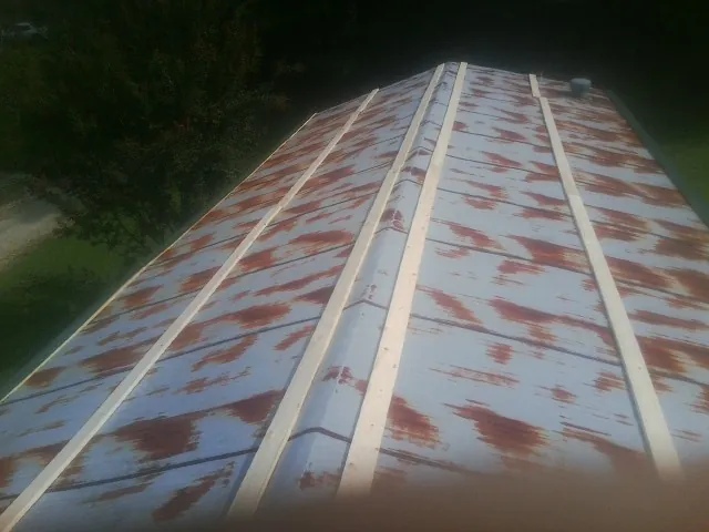 Rusted metal roof panels with new wood purlins before replacement — Storm Damage Roof Repair in Lake by Roofing Brothers