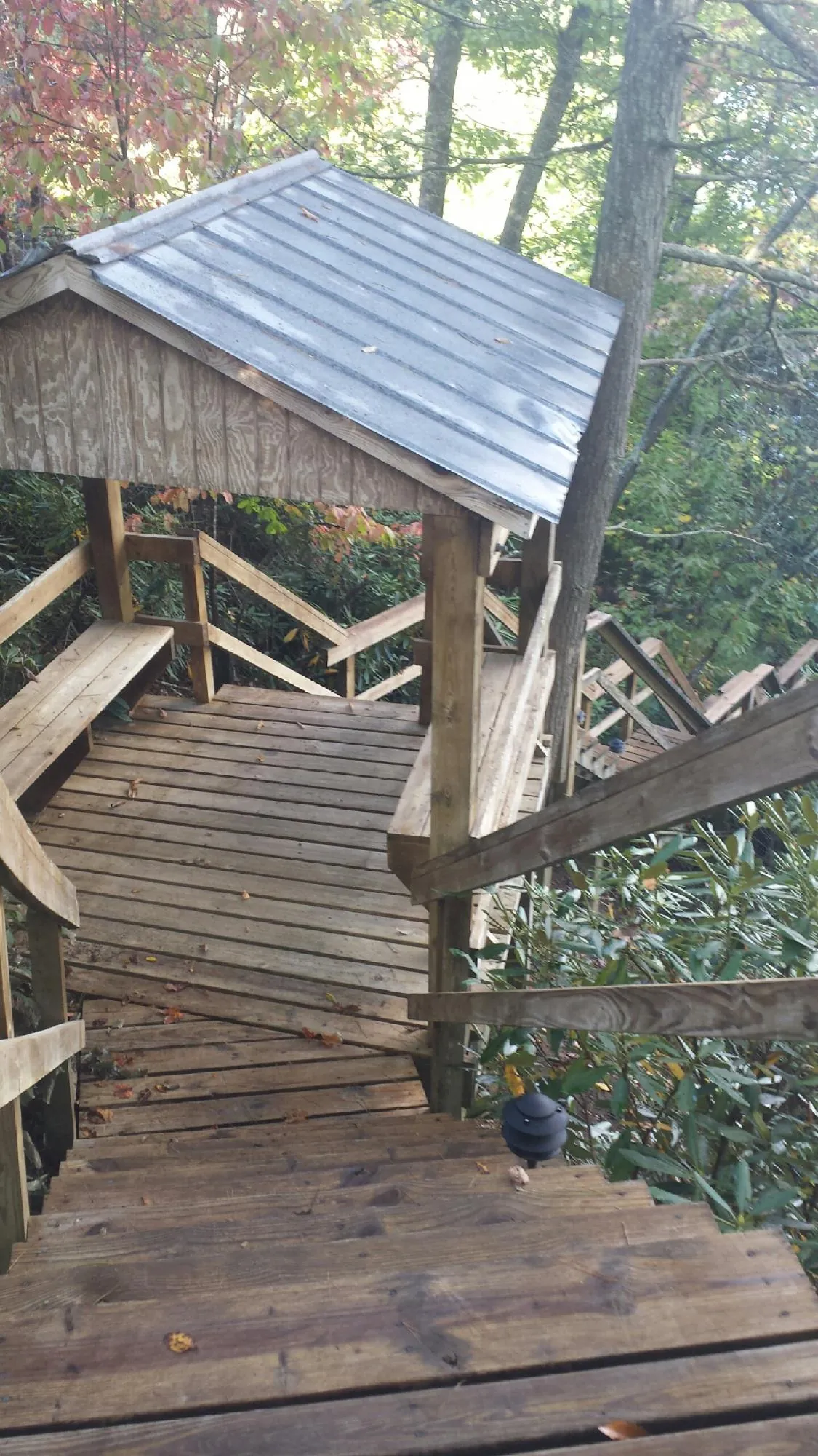 Metal roofed shelter over wooden steps on a wooded walkway — Skylight Repair & Installation work by our crew in Lake