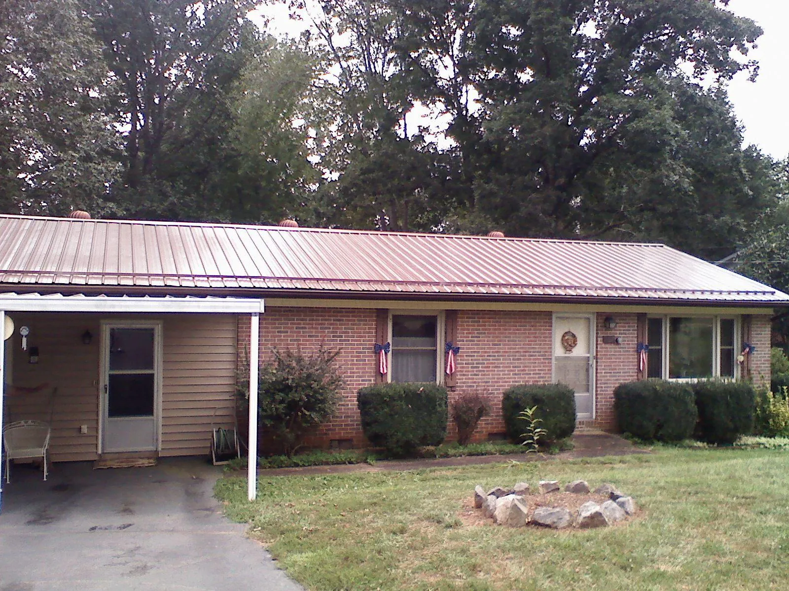 Bronze metal roof and carport on a brick ranch home — Roof Repair work by our crew in Lake