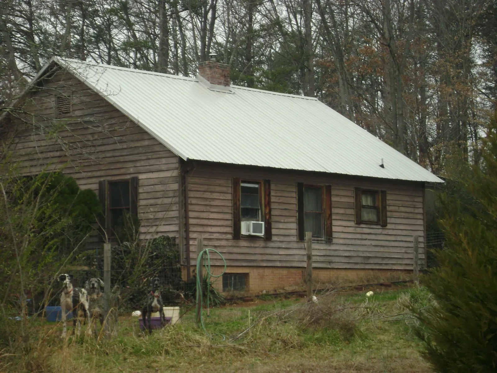 White metal roof on an old wood sided farmhouse, from a Metal Roof Installation job in Lake